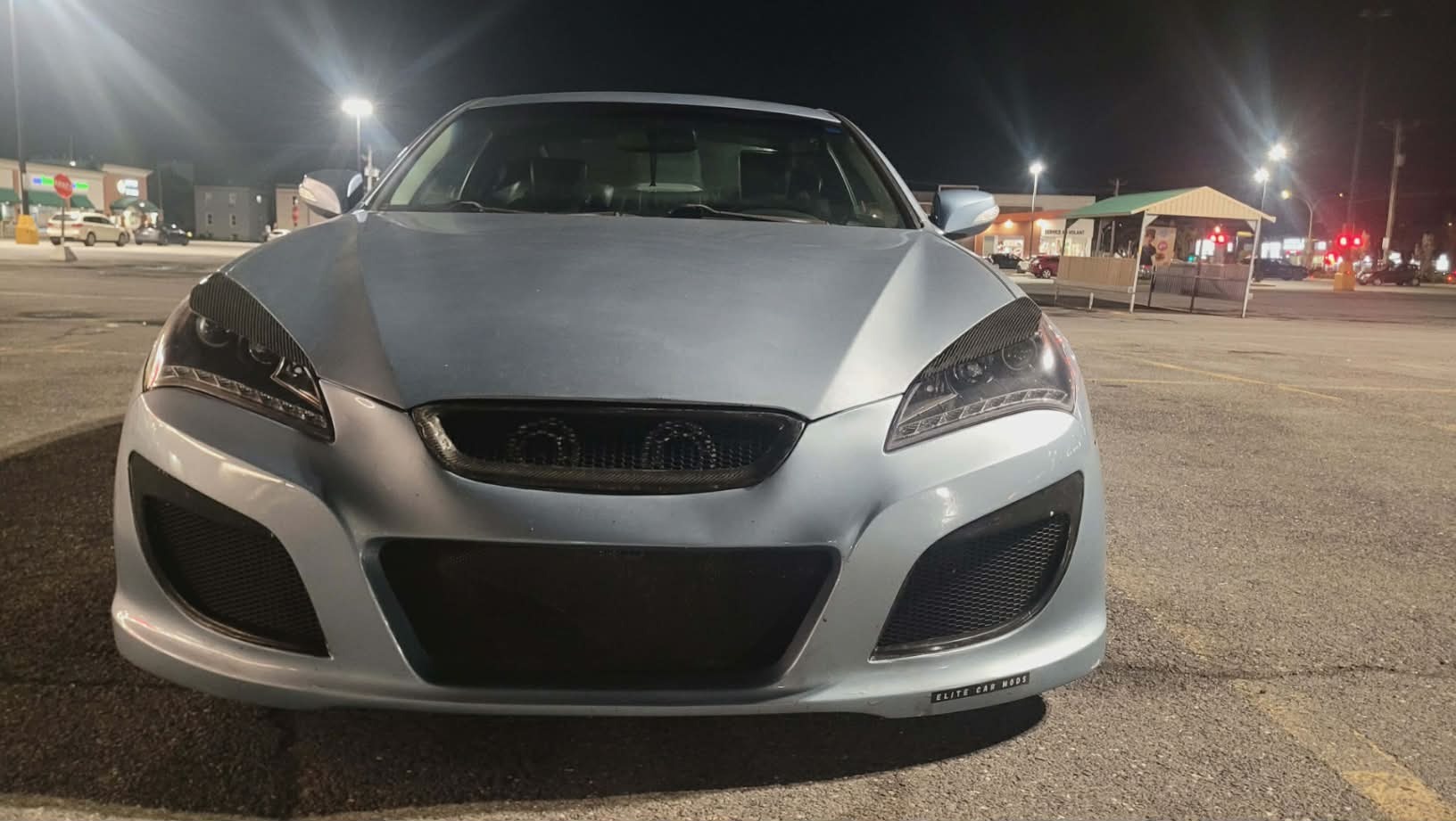Genesis Coupe de face, la nuit, avec eyelids en fibre de carbone